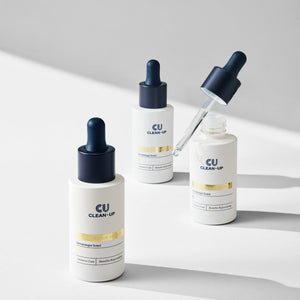 Three CU Clean-Up EX-C RE n calm ampoule skincare bottles with droppers on a light gray background.