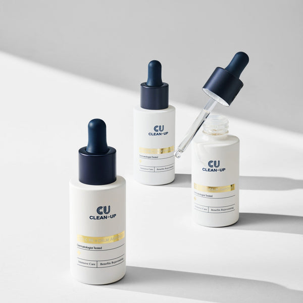 Three CU Clean-Up EX-C RE n calm ampoule skincare bottles with droppers on a light gray background.