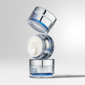 three stacks of cu vitamin u cream moisturizer with middle open container.