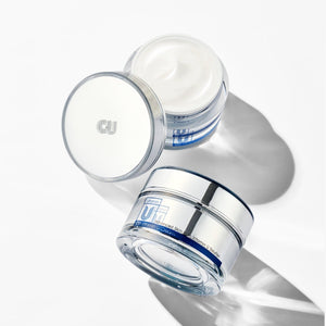 Two skincare jars of cu vitamin u cream moisturizer with visible brand logo on a white background