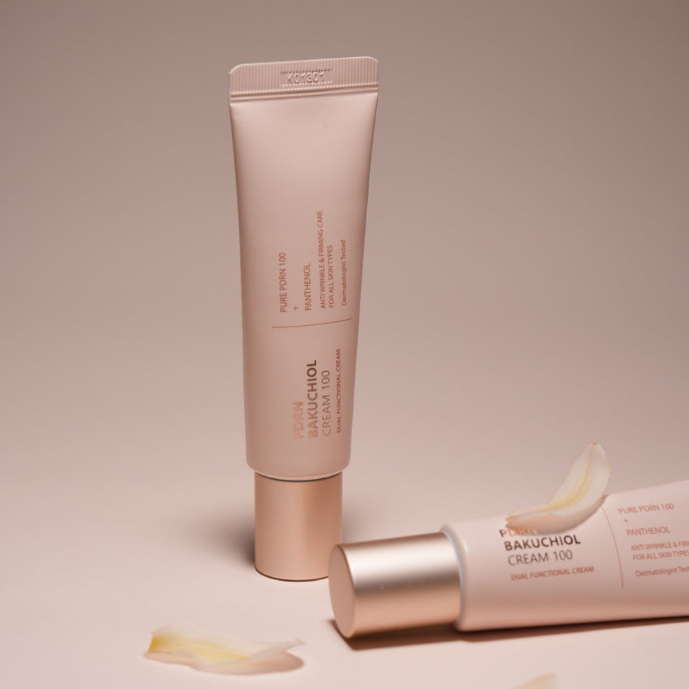 Skincare tube with silver base on a black background